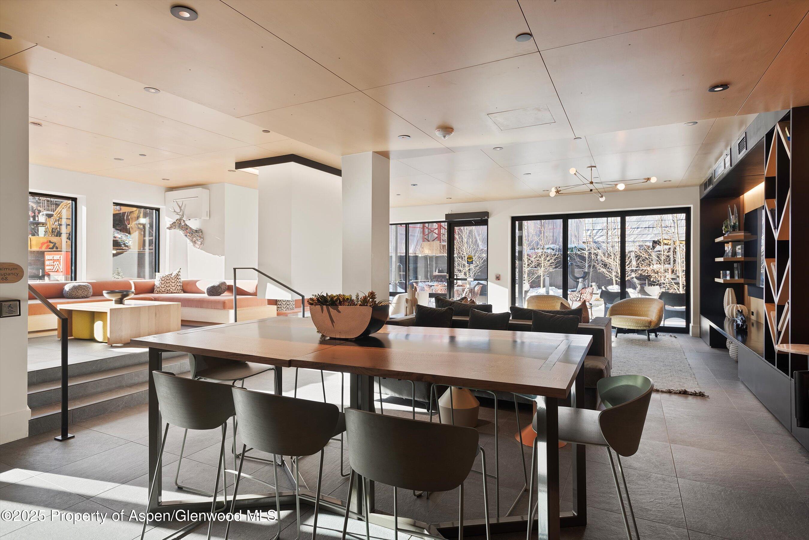 119 Wood Road, Unit 303 Snowmass Village, CO 81615 - Photo 15 of 30 a room with lots of chairs and large windows