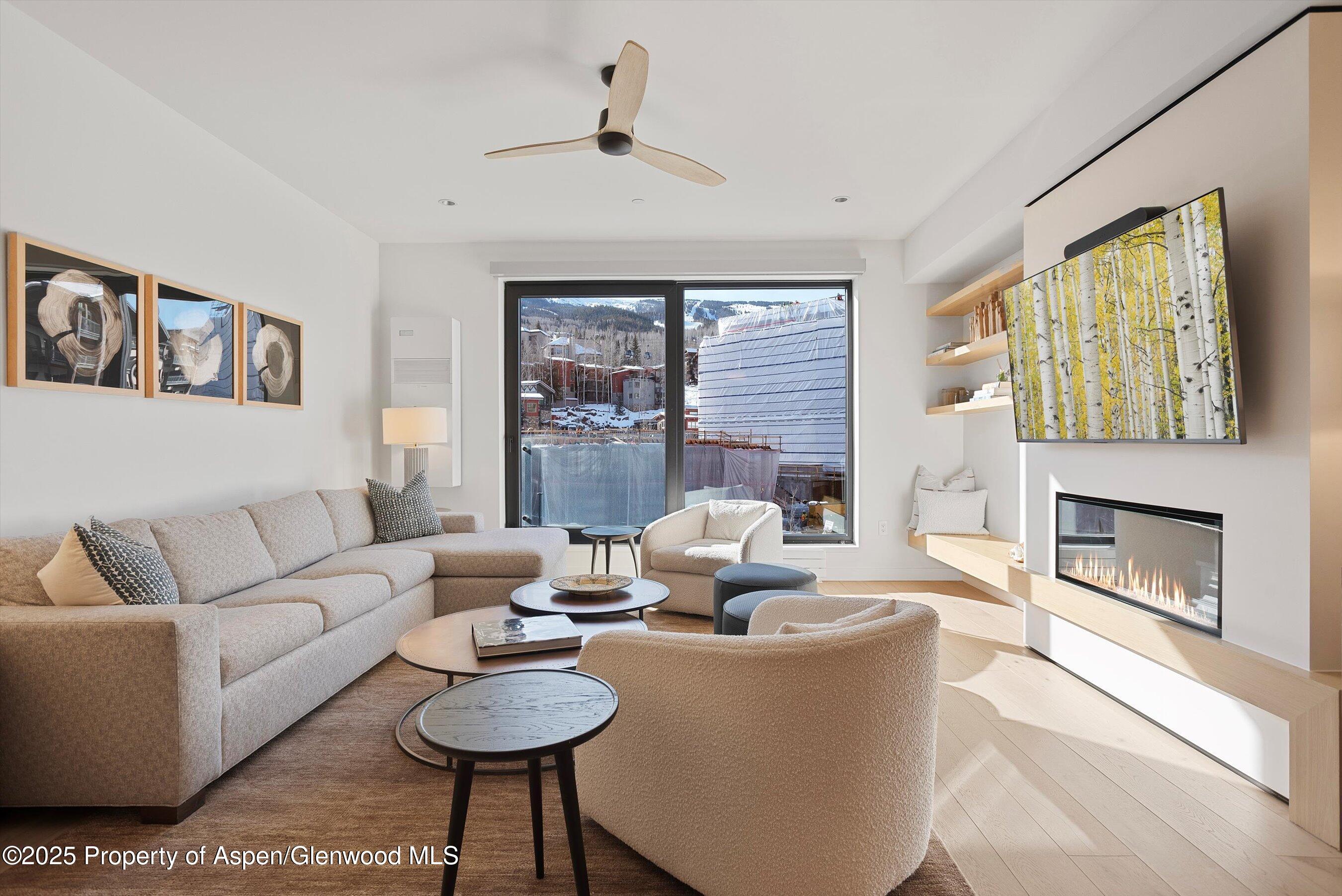 119 Wood Road, Unit 303 Snowmass Village, CO 81615 - Photo 2 of 30 a living room with furniture a fireplace and a large window