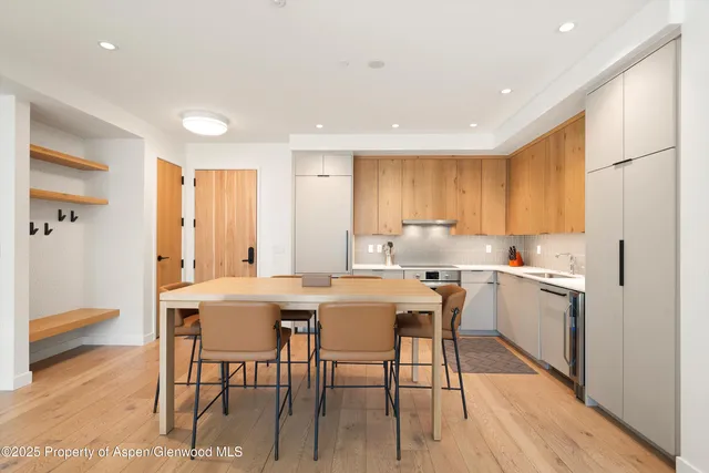 a kitchen with a table chairs refrigerator and cabinets