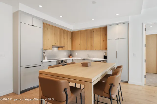 a kitchen with a table chairs refrigerator and cabinets