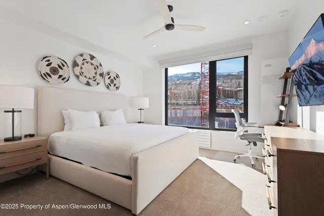a large white bed sitting in a room next to a window