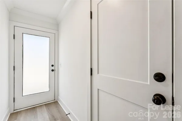 a view of a hallway with stairs and wooden floor