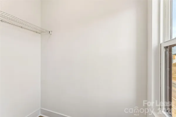 a view of a room with wooden floor and a ceiling fan