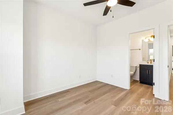 a bathroom with a bathtub shower sink vanity mirror and toilet