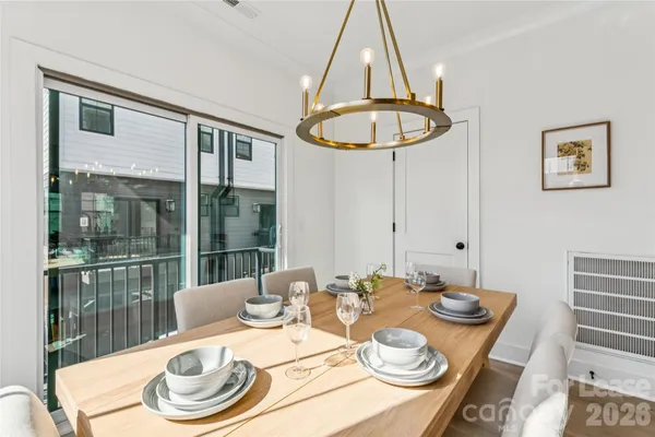 a dining room with furniture a chandelier and wooden floor