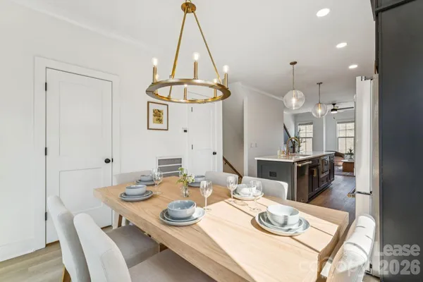 a dining room with furniture a chandelier and wooden floor