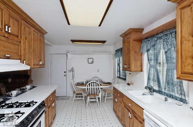 1702 Fitzgerald Road Simi Valley, CA 93065 - Photo 6 of 12 a kitchen with a sink stove and wooden cabinets
