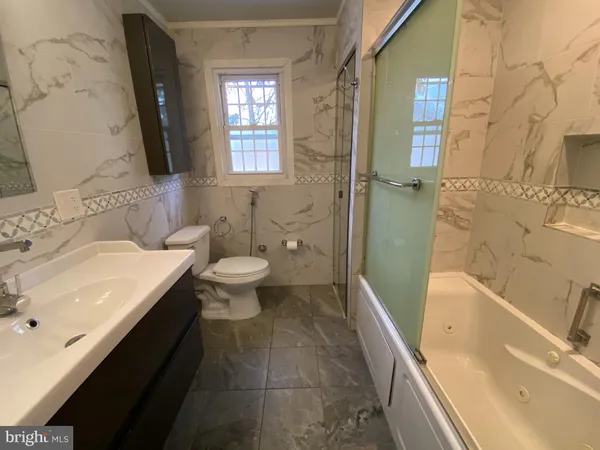 a bathroom with a sink a toilet and bathtub