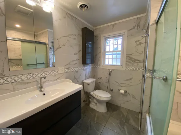 a bathroom with a sink toilet a mirror and shower
