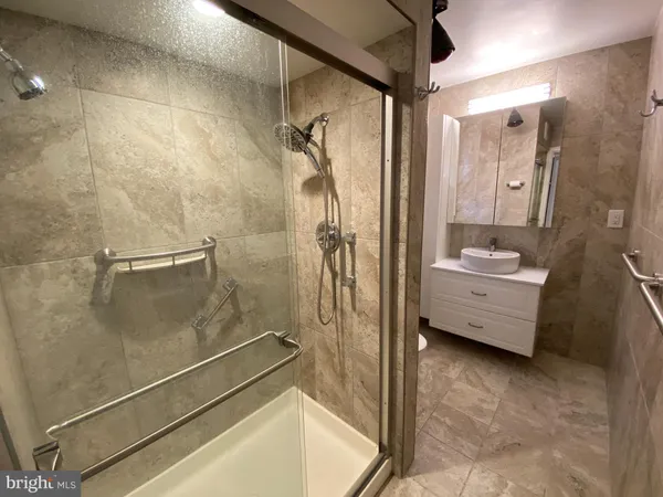 a bathroom with a tub shower vanity and a sink