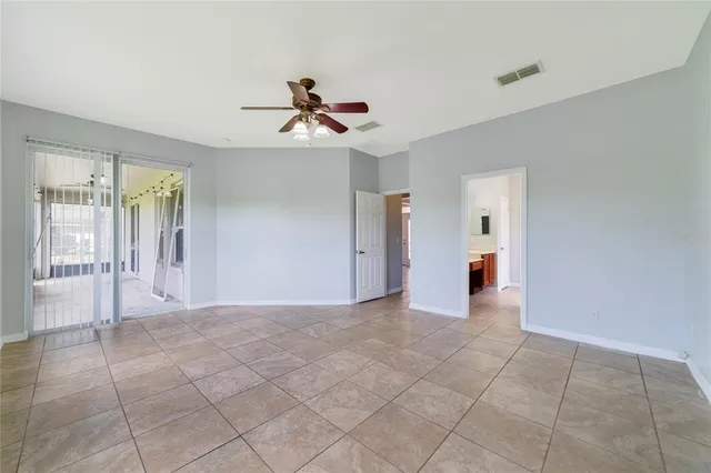 a view of a livingroom with a chandelier fan and windows