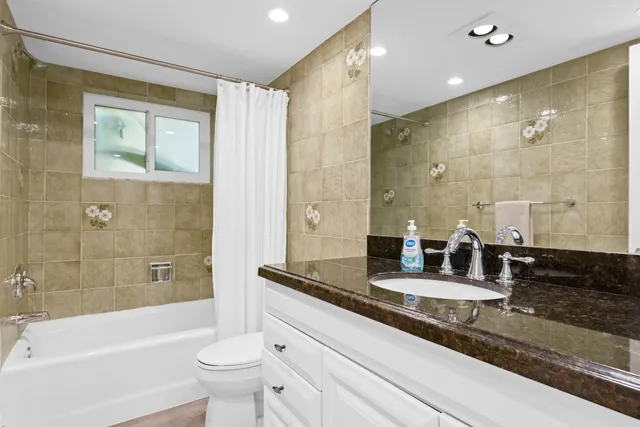 a bathroom with a granite countertop tub sink and mirror