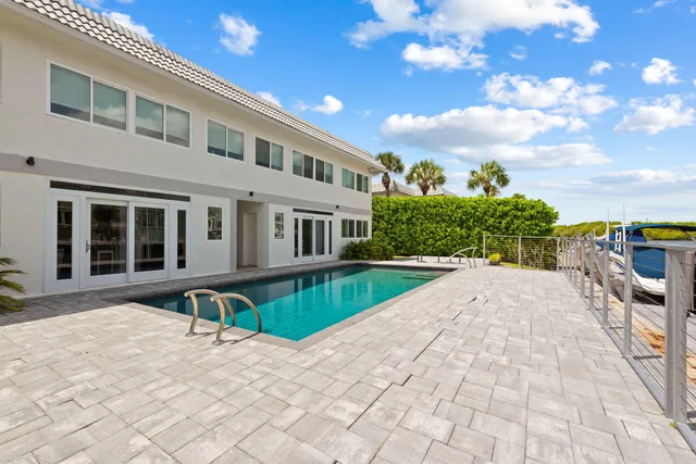 a front view of a house with a yard and potted plants