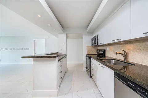 a kitchen with granite countertop a sink and a stove top oven