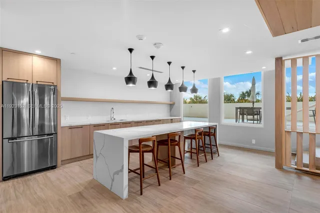 a kitchen with stainless steel appliances granite countertop a table chairs stove and refrigerator
