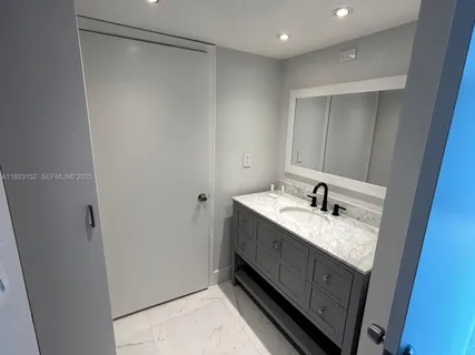 a bathroom with a granite countertop sink and a mirror