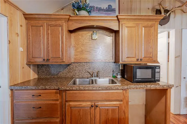 a kitchen with stainless steel appliances dining table chairs and wooden floor