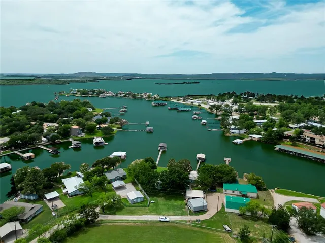 an aerial view of water body with boats and residential houses with outdoor space
