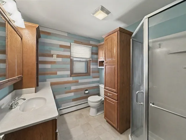 a bathroom with a sink a toilet and shower