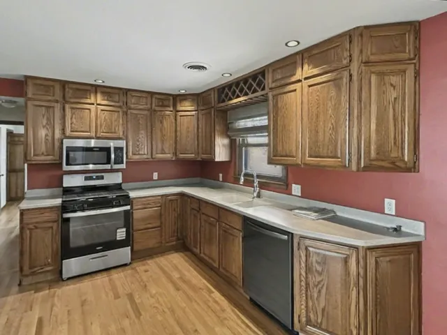 a kitchen with stainless steel appliances granite countertop a sink stove and microwave