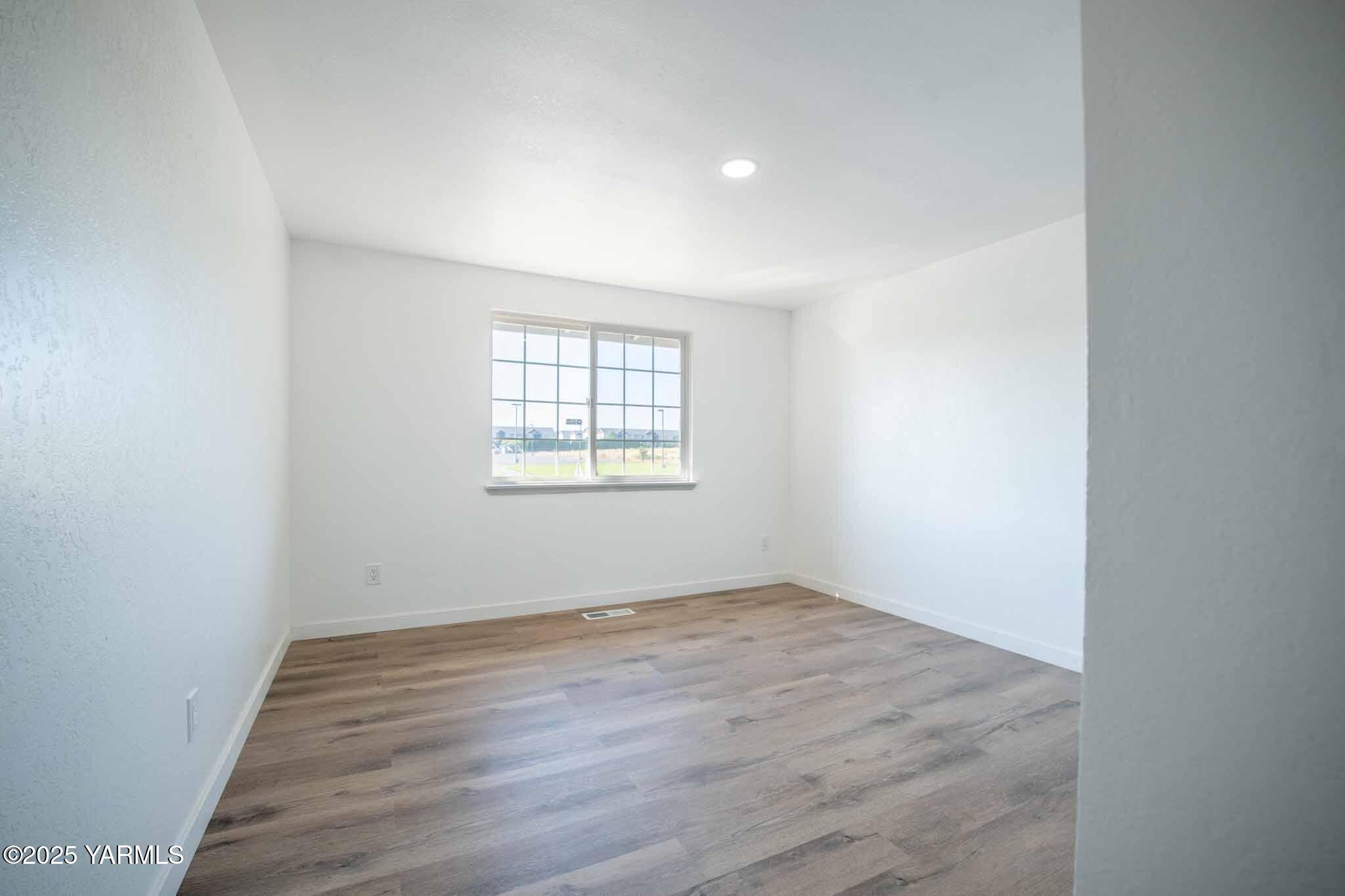 4711 Carol Avenue Yakima, WA 98908 - Photo 12 of 28 an empty room with wooden floor and windows