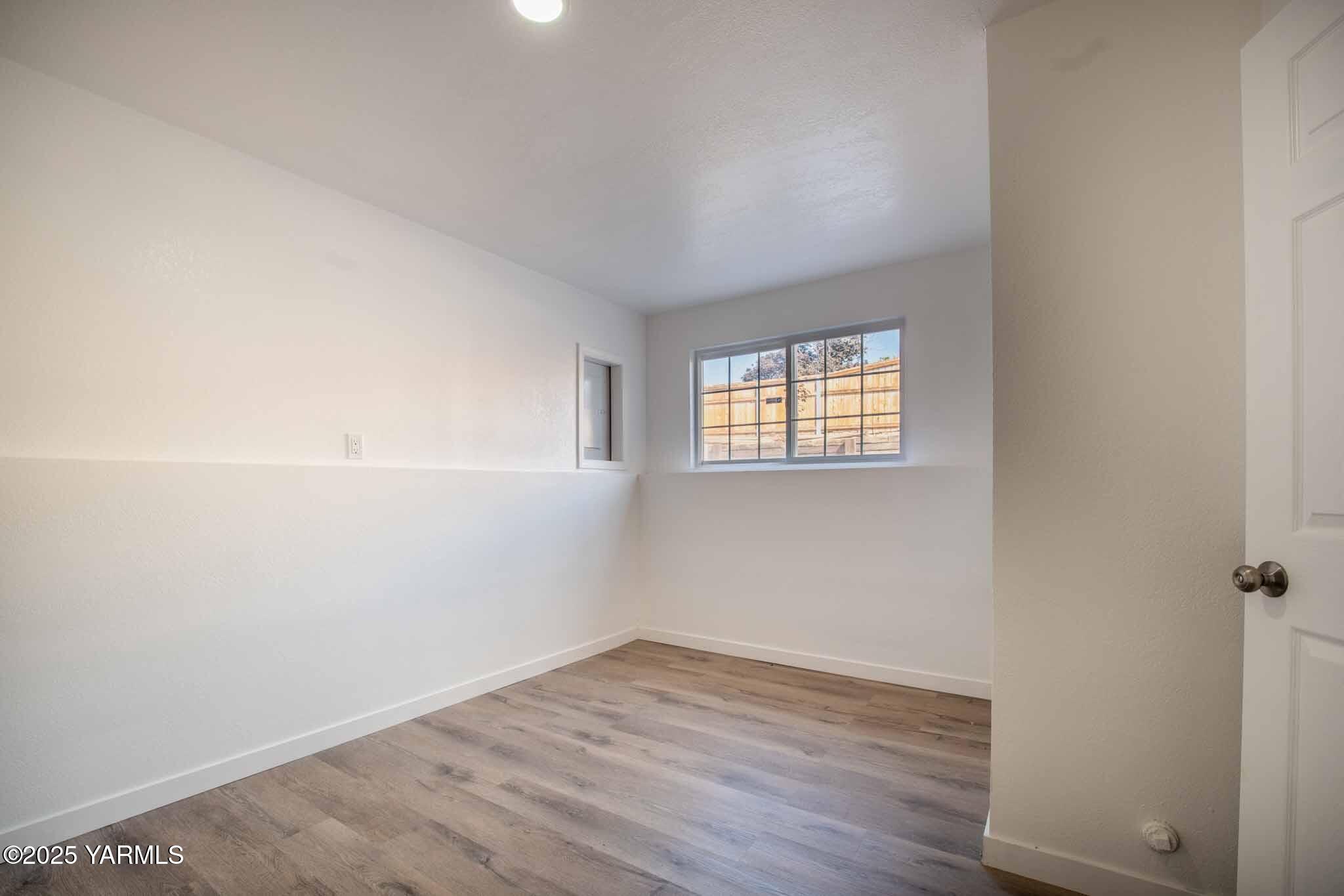 4711 Carol Avenue Yakima, WA 98908 - Photo 21 of 28 an empty room with wooden floor and windows