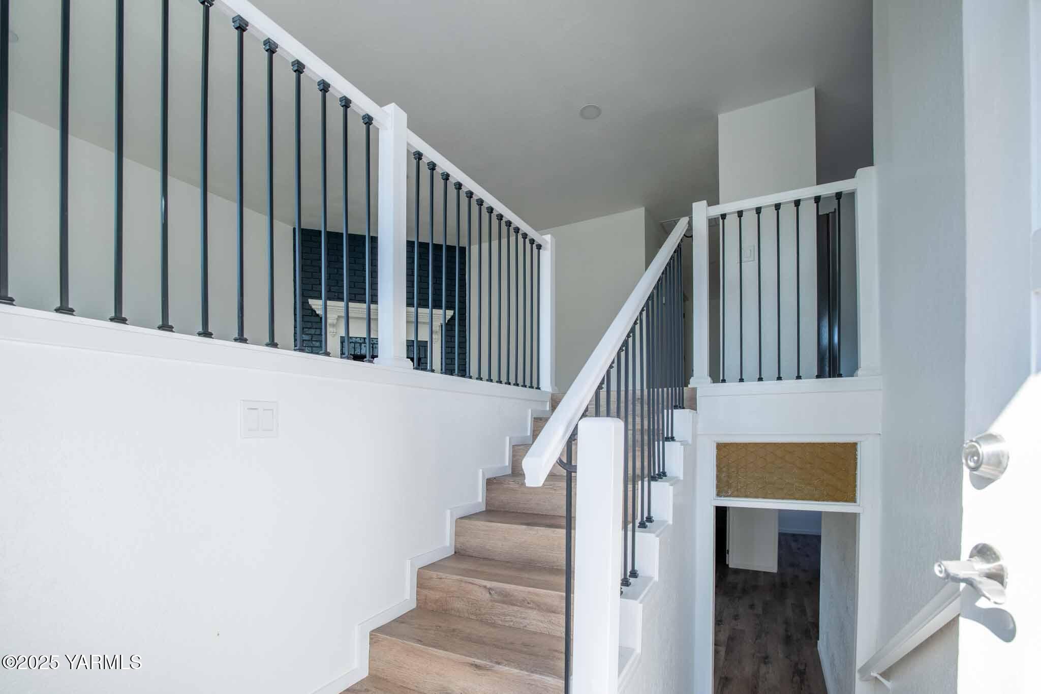 4711 Carol Avenue Yakima, WA 98908 - Photo 3 of 28 a view of staircase with lots of frames on wall and a view of a staircase