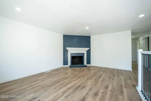 a view of an empty room with a fireplace and a window