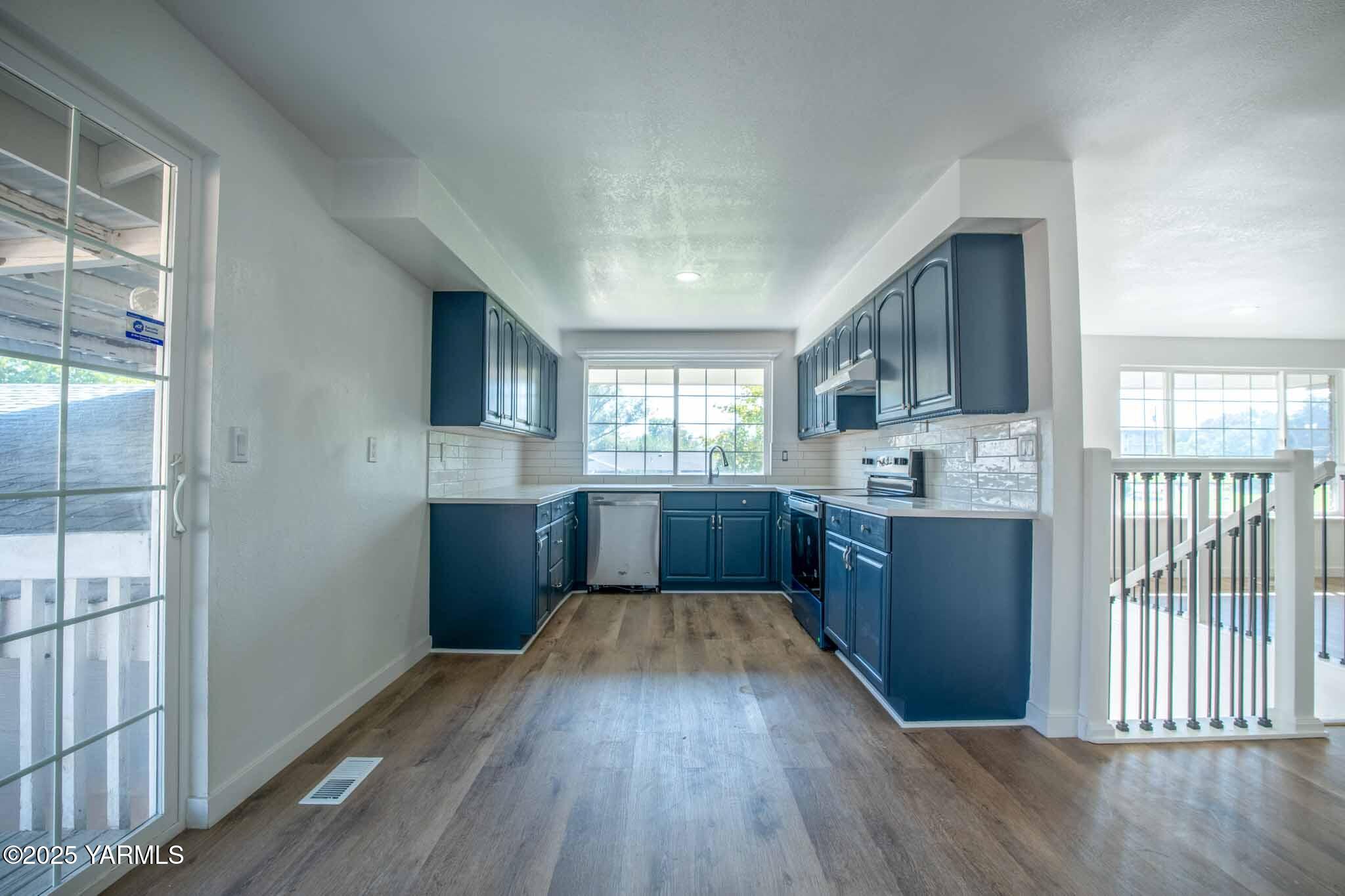 4711 Carol Avenue Yakima, WA 98908 - Photo 6 of 28 a large kitchen with a wooden floor and cabinets