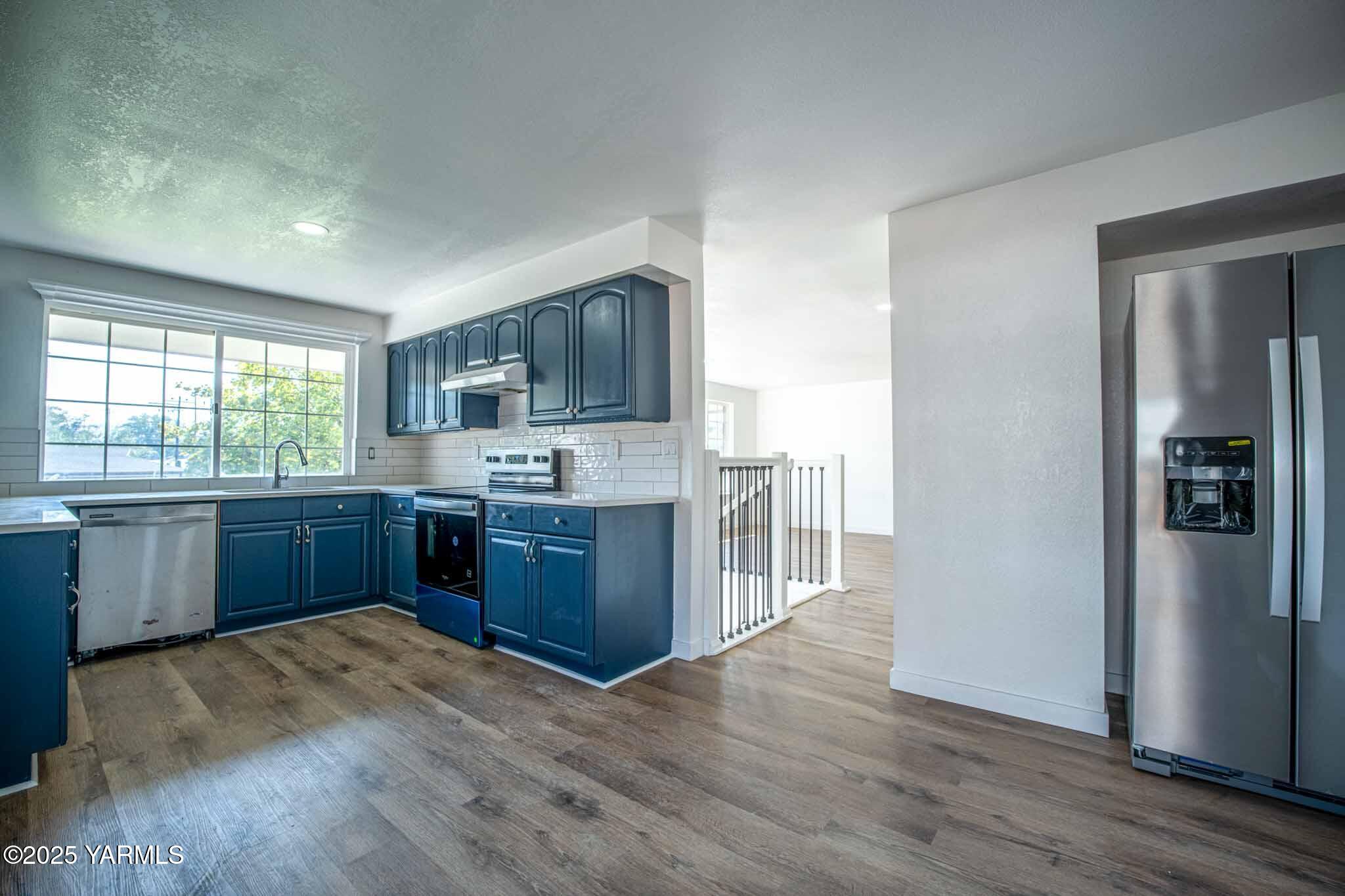 4711 Carol Avenue Yakima, WA 98908 - Photo 7 of 28 a kitchen with stainless steel appliances kitchen island granite countertop a refrigerator sink and wooden cabinets