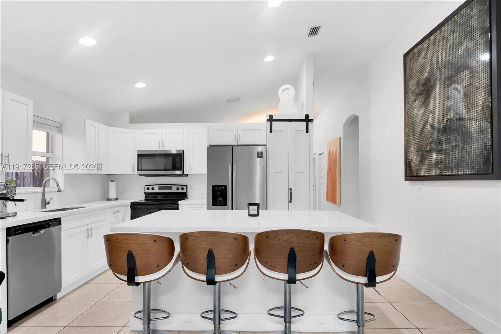 1959 Southeast 10th Street Homestead, FL 33035 - Photo 22 of 39 a kitchen with granite countertop a table chairs stove and cabinets