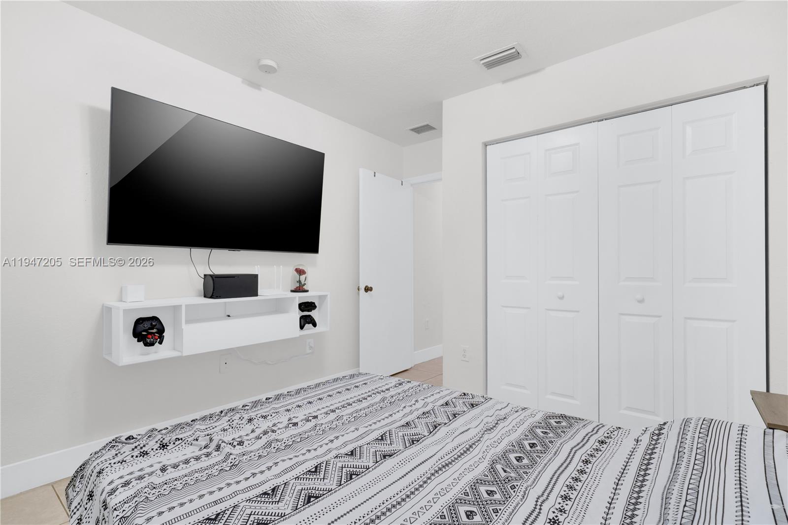 1959 Southeast 10th Street Homestead, FL 33035 - Photo 5 of 39 a view of a bedroom with a flat screen tv