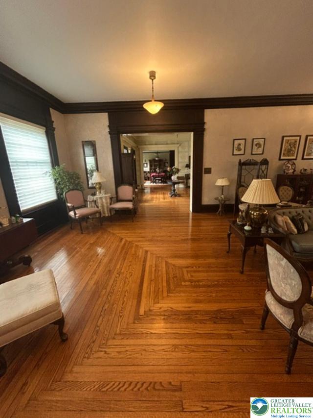 1170 Mosser Road Breinigsville, PA 18031 - Photo 17 of 19 Herringbone hardwood floors extend through this grand living area, framed by ornate dark wood trim.