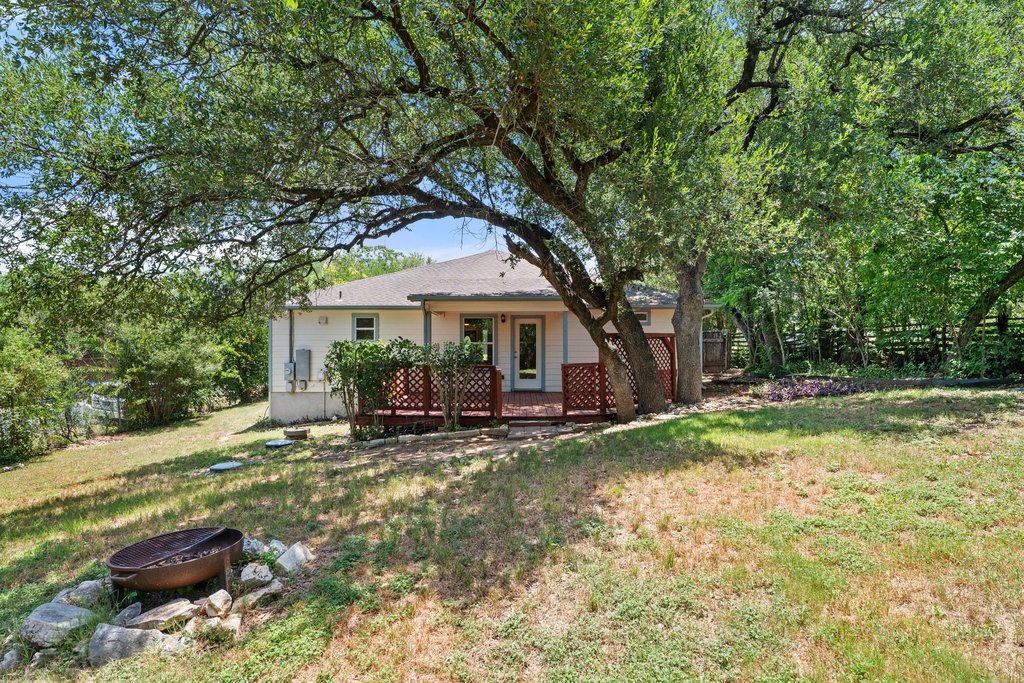 5208 Sioux Lane Austin, TX 78734 - Photo 32 of 35 Mature trees shade a peaceful backyard with a ready-to-entertain deck and a rustic fire pit.