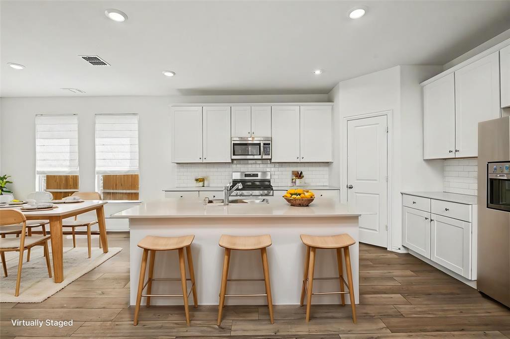 10004 Thornapple Road Fort Worth, TX 76179 - Photo 11 of 39 a kitchen with granite countertop white cabinets and stainless steel appliances