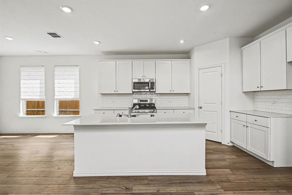 10004 Thornapple Road Fort Worth, TX 76179 - Photo 12 of 39 a kitchen with stainless steel appliances granite countertop a stove a sink and white cabinets