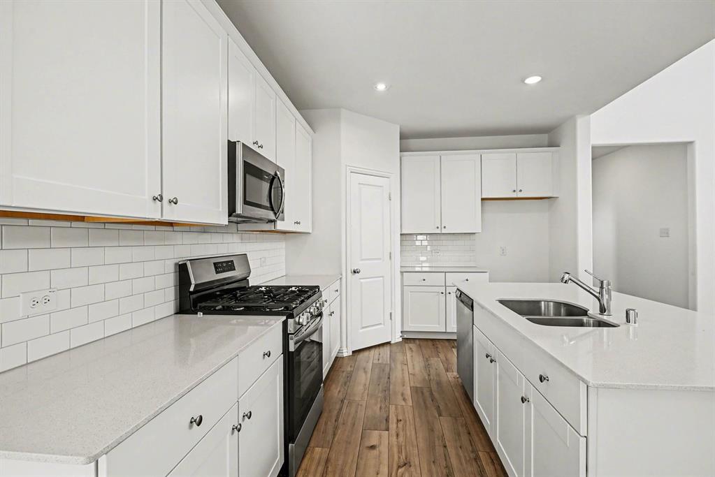 10004 Thornapple Road Fort Worth, TX 76179 - Photo 13 of 39 a kitchen with granite countertop a sink a stove and cabinets