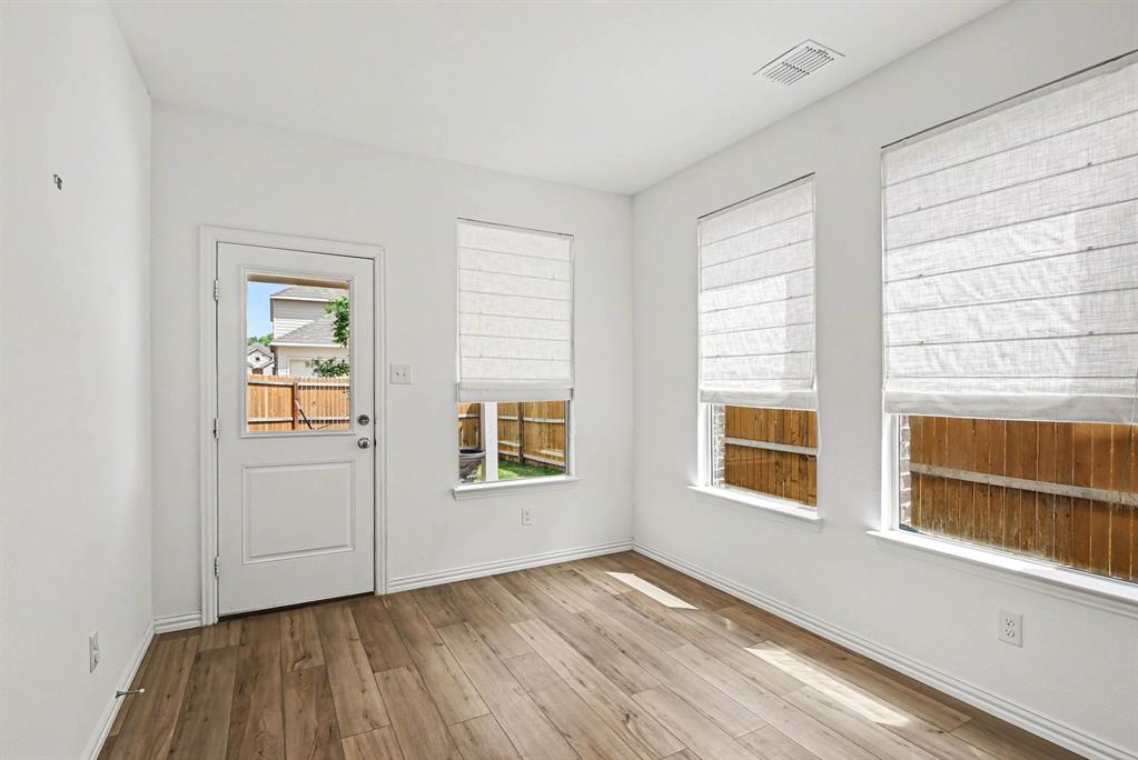 10004 Thornapple Road Fort Worth, TX 76179 - Photo 31 of 39 an empty room with wooden floor and windows