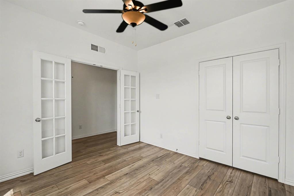 10004 Thornapple Road Fort Worth, TX 76179 - Photo 6 of 39 an empty room with wooden floor cabinet and windows