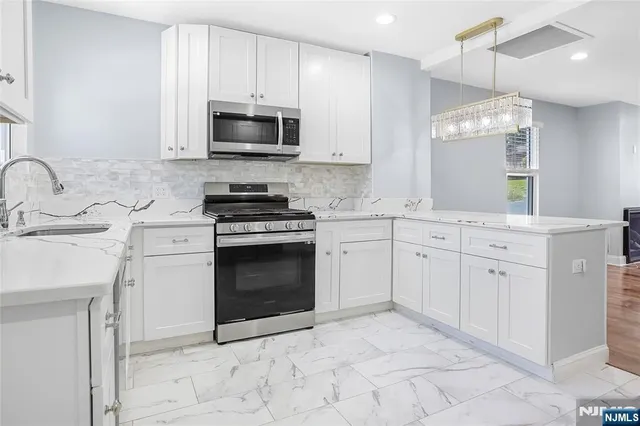 a kitchen with white cabinets and stainless steel appliances
