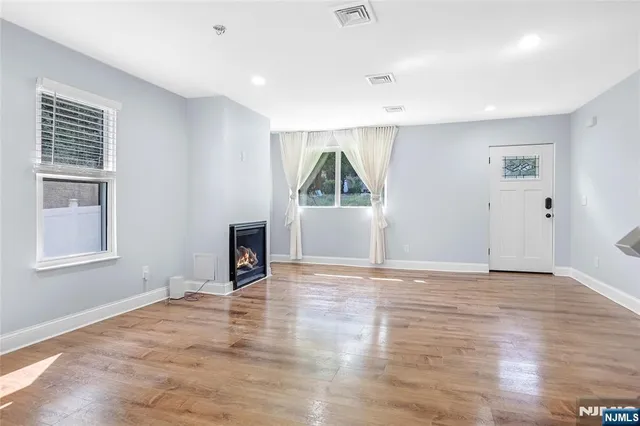 an empty room with windows and fireplace