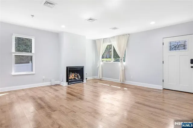 an empty room with windows and fireplace