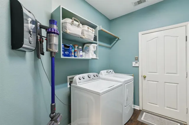 a spacious bedroom with a bed and a flat tv screen on dresser
