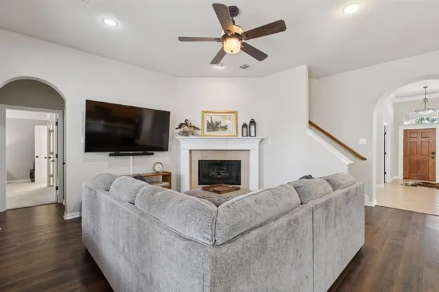 a living room with furniture a flat screen tv and a fireplace
