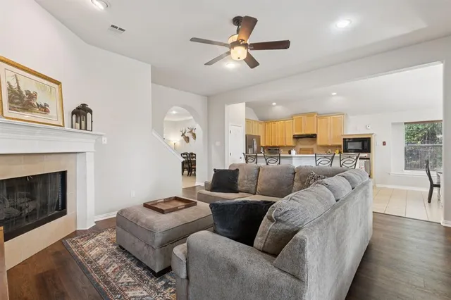 a living room with furniture kitchen view and a fireplace
