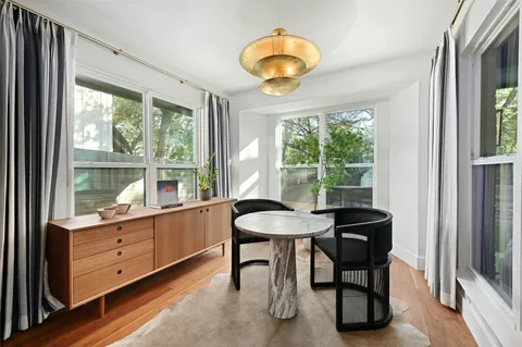 a room with a table chair and a large window