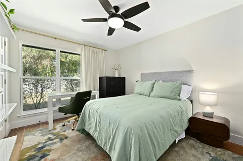 a bedroom with a bed and a large window