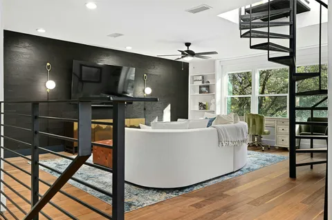 a living room with large window and furniture