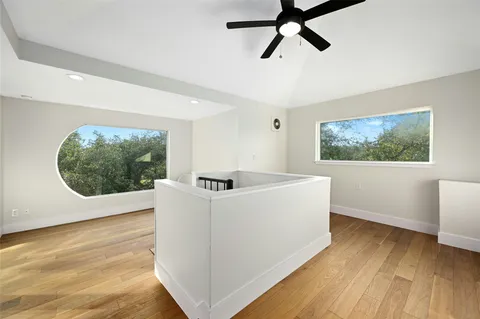 a view of a room with wooden floor and a ceiling fan