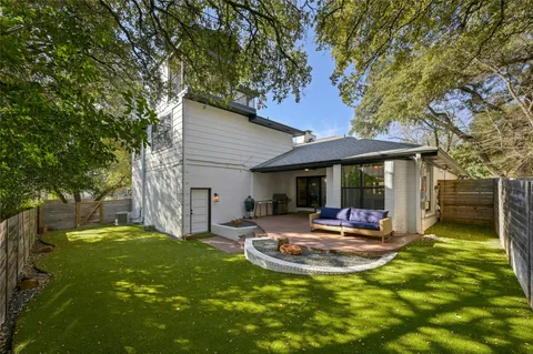 a view of a backyard with table and chairs and a large tree